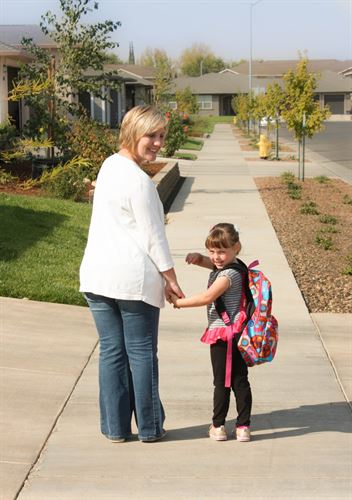 Photo of mom and daughter walking to school.